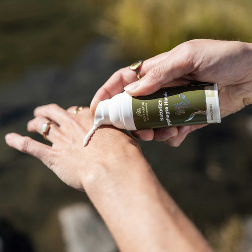 Handcreme wird auf die Hände getragen